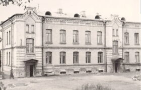 Монохромное фото краснокирпичного жилого дома, входящего в комплекс казённого винного склада № 7. В 1918 году после революции в административном здании склада размещался уездный совет народных депутатов. В годы Великой Отечественной войны в здании располагалось управление завода № 621. Теперь - главное здание Акмолинского областного историко-краеведческого музея.